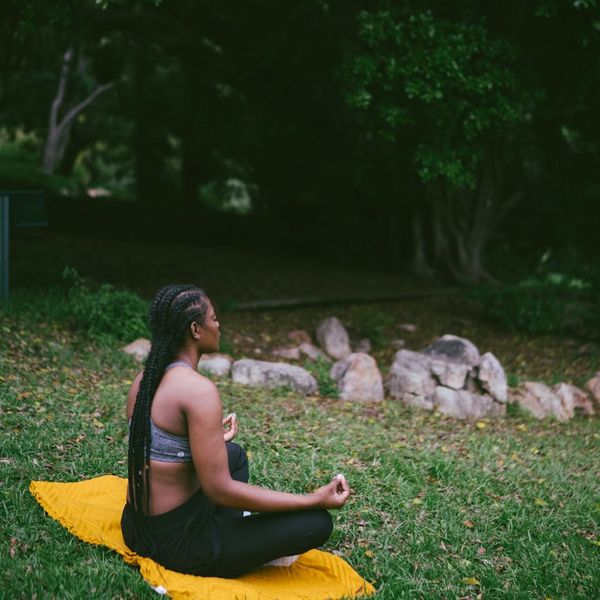 Woman meditating peacefully in a beautiful natural setting.